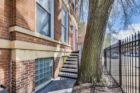 Front view of a brick building with a staircase leading to the entrance.