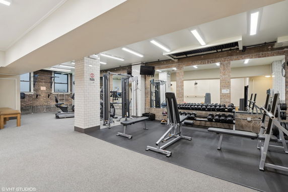 Interior view of a gym with various fitness equipment and weights.