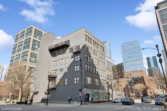 Front view of a multi-story building on a city street corner.
