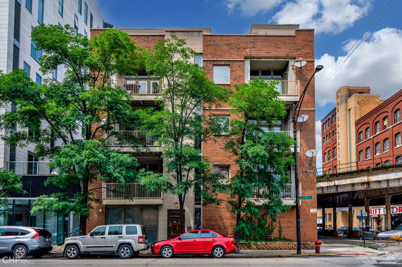 Front view of a multi-story brick building with balconies.