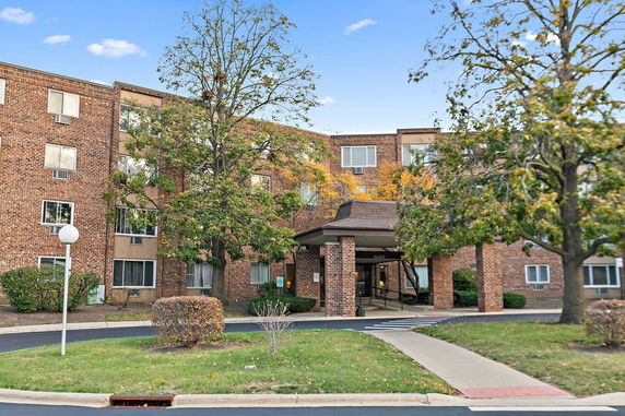 Front view of a multi-story brick building with an entrance canopy.