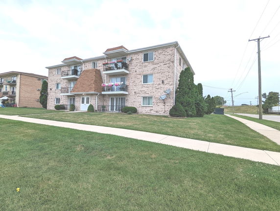 Front view of a three-story apartment building with balconies.