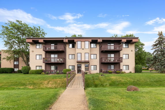 Front view of a three-story apartment building with balconies.
