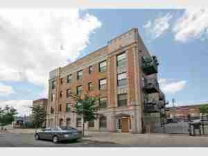 Front view of a multi-story brick apartment building.