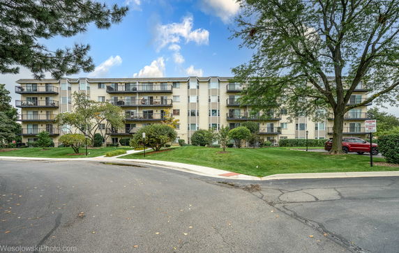 Front view of a multi-story apartment building with balconies.