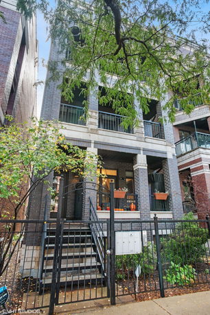 Front view of a multi-story building with brick exterior and balconies.