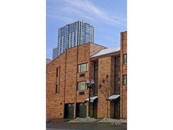 Front view of a brick multi-story building with garage doors and windows.
