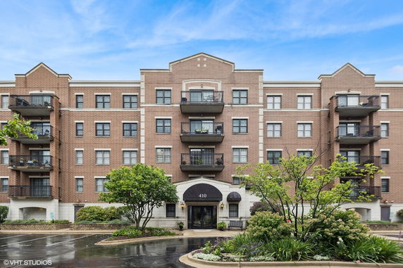 Front view of a multi-story brick apartment building with balconies.