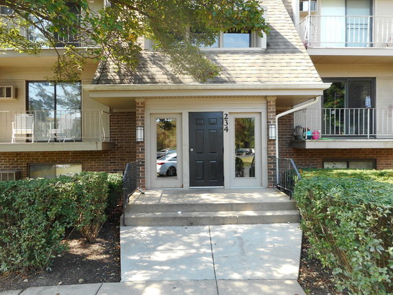 Front view of a residential building with balconies and a main entrance.