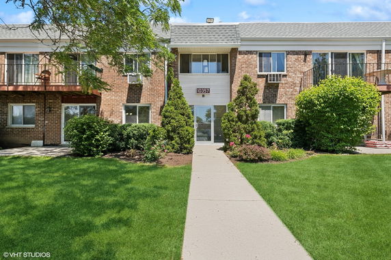 Front view of a two-story brick apartment building with balconies.