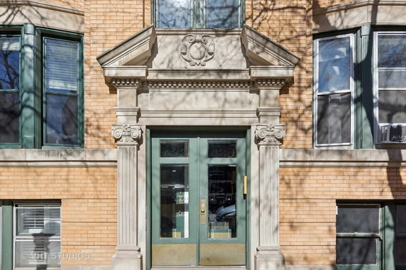 Front view of a brick building with decorative door frame and windows.