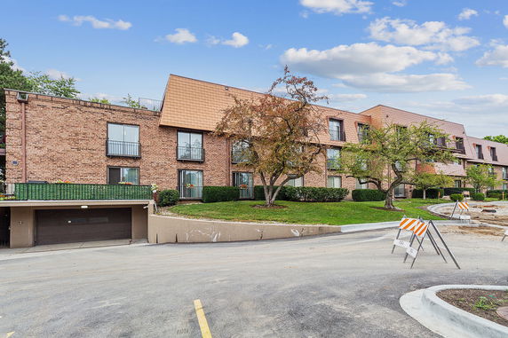 Front view of a multi-story brick building with multiple windows and small balconies