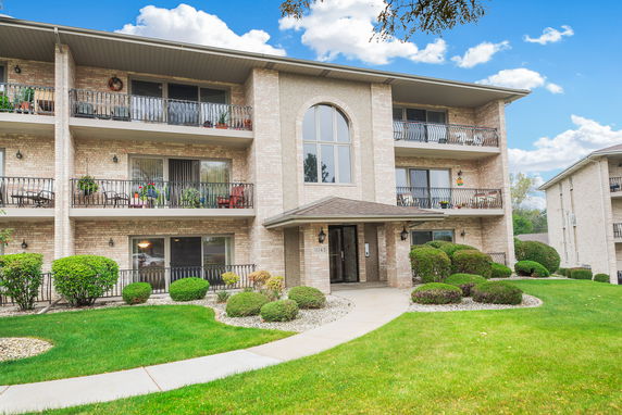 Front view of a three-story apartment building with balconies.