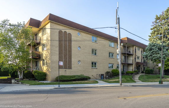 Front view of a multi-story apartment building with balconies.