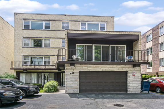 Front view of a multi-story residential building with a garage.