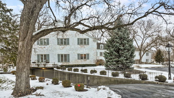 Front view of a two-story house with white brick exterior and blue shutters.