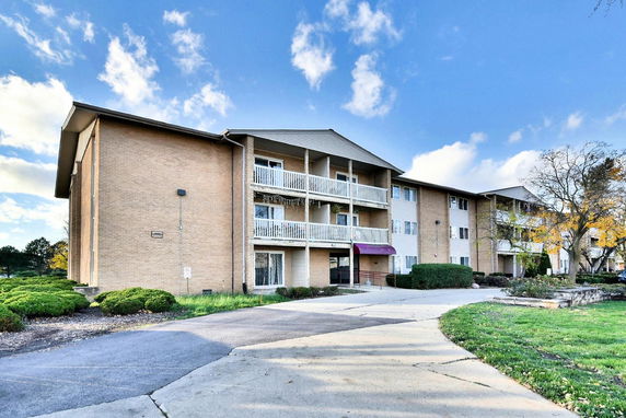 Front view of a multi-story apartment building with balconies.