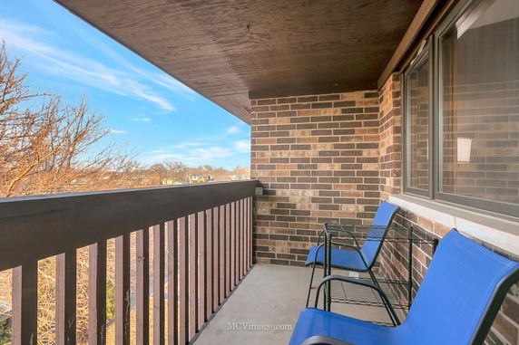 View from a balcony with chairs overlooking surrounding areas.