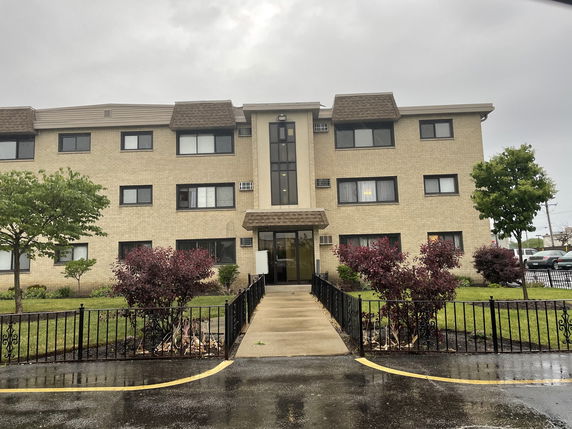 Front view of a three-story residential building with a symmetrical design.