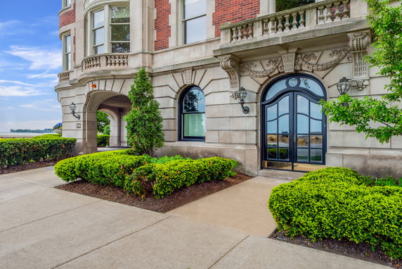 Front view of a building with decorative stonework and arched windows.