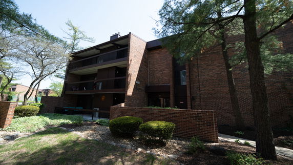 Front view of a multi-story brick apartment building with balconies.