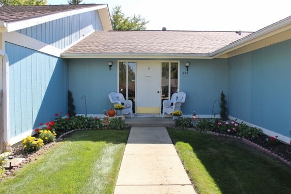 Front view of a house with blue siding and a small porch entrance.