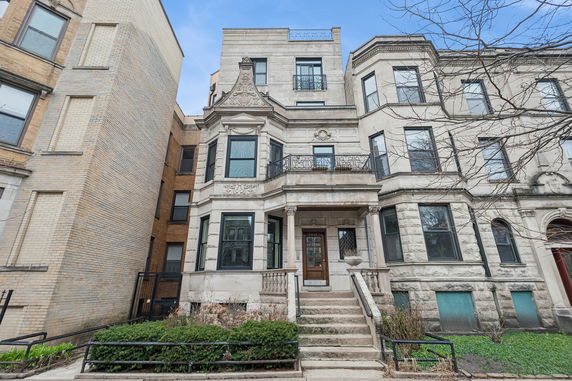 Front view of a multi-story stone building with decorative details.