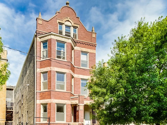Front view of a multi-story brick building with ornate architectural details.
