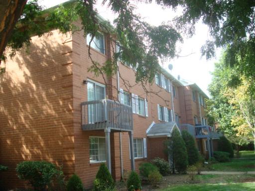 Front view of a multi-story brick apartment building with balconies.