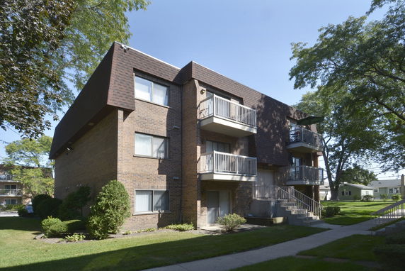 Front view of a multi-story apartment building with balconies.