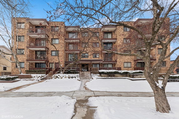 Front view of a multi-story brick apartment building in winter.