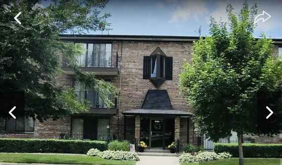 Front view of a multi-story brick building with balconies.