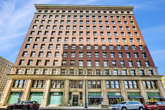 Front view of a multi-story brick building with numerous windows.