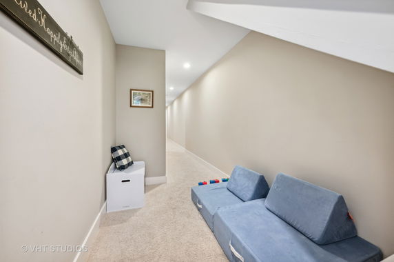 Indoor hallway with seating and children's play items.
