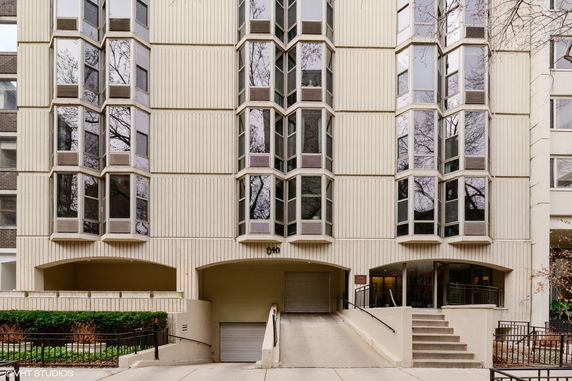 Front view of a multi-story building with bay windows and garage entrance.
