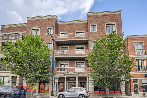 Front view of a multi-story brick building with balconies.