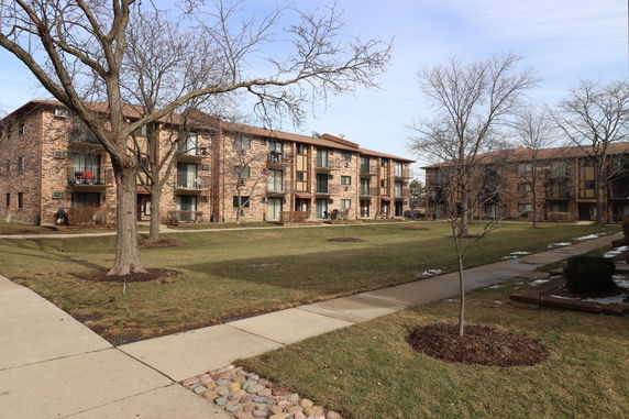 Front view of a multi-story apartment building with balconies.