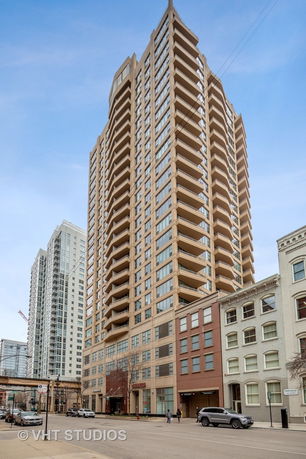 Front view of a tall apartment building with multiple balconies.