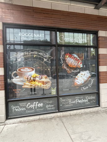 Front view of a cafe storefront with promotional window displays.