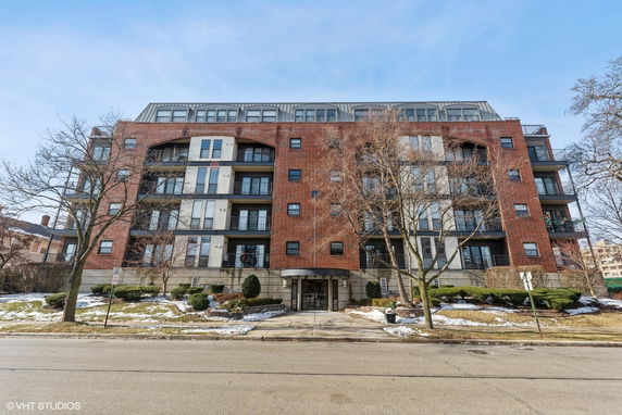 Front view of a multi-story brick building with balconies.