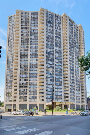 Front view of a tall residential building with many windows and balconies.