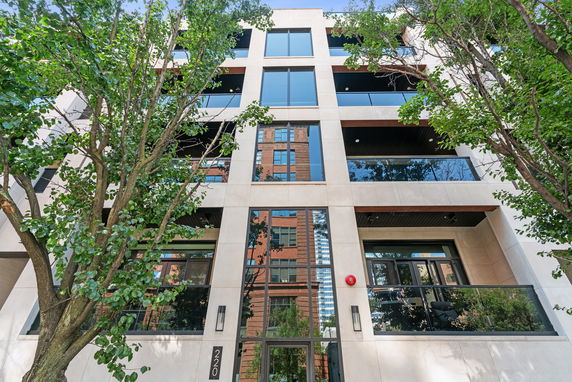 Front view of a multi-story building with large windows and balconies.