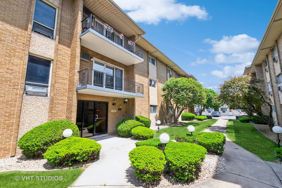 Front view of a multi-story apartment building with balconies.