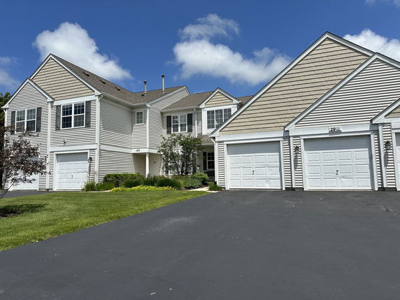 Front view of a two-story house with multiple garages.