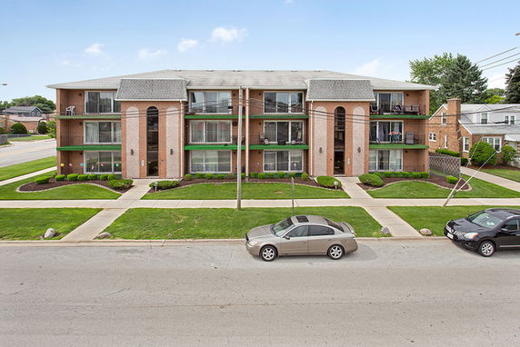 Front view of a multi-story apartment building with balconies.