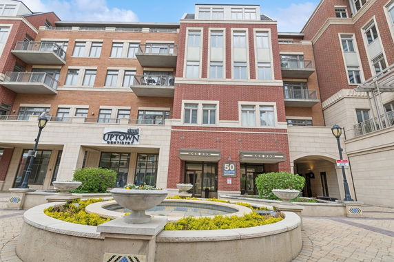 Front view of a multi-story building with brick façade and multiple balconies.