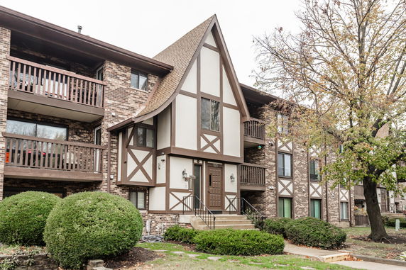 Front view of a multi-story building with Tudor-style architecture and brick exterior.