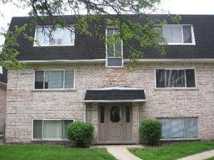 Front view of a multi-story brick building with a dark roof.
