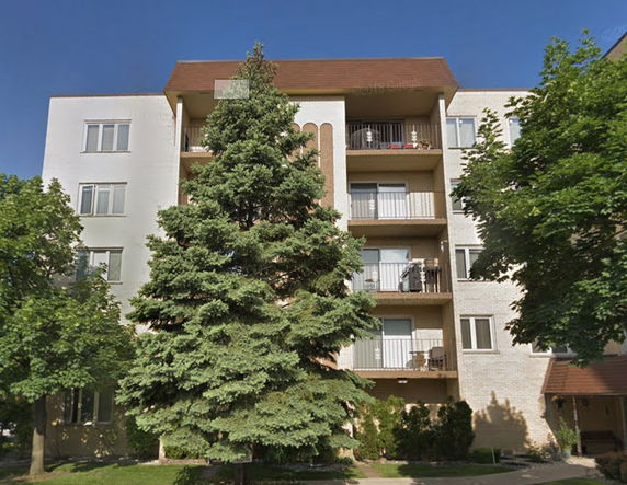 Front view of a multi-story apartment building with balconies.