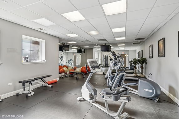 Indoor gym area with exercise equipment and mirrors.